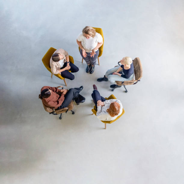istock Young woman talking in group therapy session 1372536470