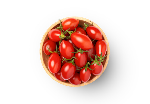 Fresh red cherry tomatoes with half sliced in wooden bowl isolated on white background. Top view. Flat lay.
