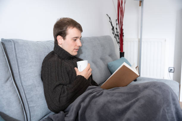 istock Man reading and holding cup of coffee 1372537790
