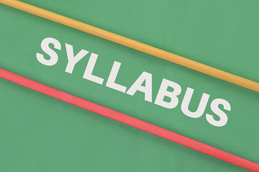 Wooden sticks over green background written with SYLLABUS.