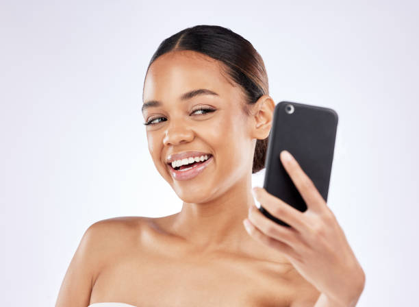 istock Shot of a young woman talking selfies using a smartphone against a studio background 1372542541