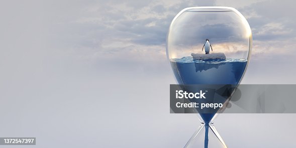 istock Hourglass Filled With Water and Penguin Floating on Ice 1372547397
