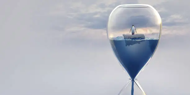 Photo of Hourglass Filled With Water and Penguin Floating on Ice