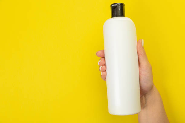 istock Cleaner's hand holding a  chemical spray bottle. Empty space for text or logo on a yellow background. Early spring or regular cleaning. Cleaning and cleaning concept. 1372549889