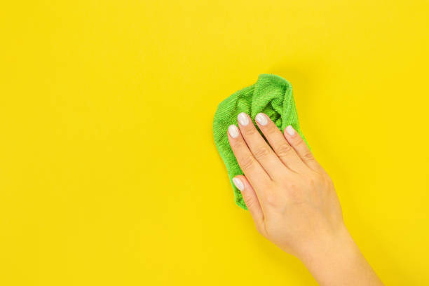 istock A housewife's hand holds a rag for dusting or washing. Empty space for text or logo on a yellow background. Early spring or regular cleaning. Cleaning and cleaning concept. 1372550010