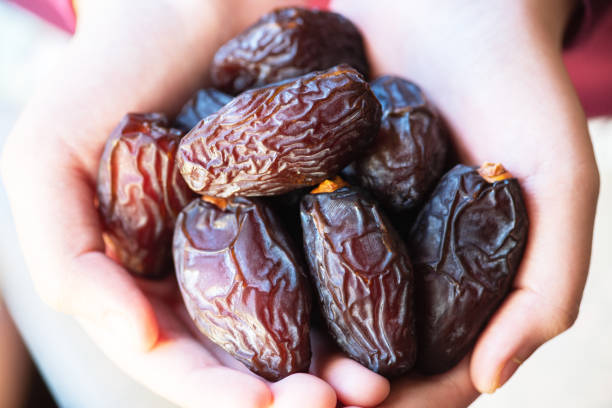 istock Dried date fruits in a hand. Close up. 1372552819