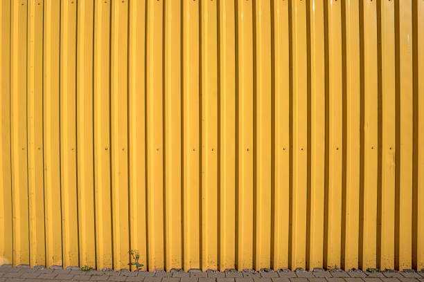 istock Corrugated empty yellow colored high fence made from steel sheet 1372557862