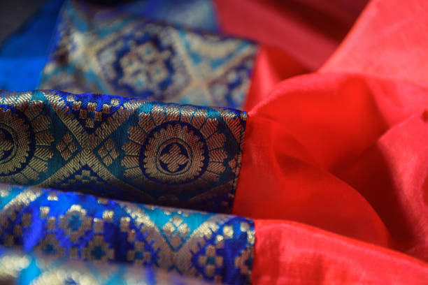 Stock photo of beautiful red color silk saree with blue and golden color border, Picture captured under natural light at Bangalore, Karnataka, India. focus on object. stock photo