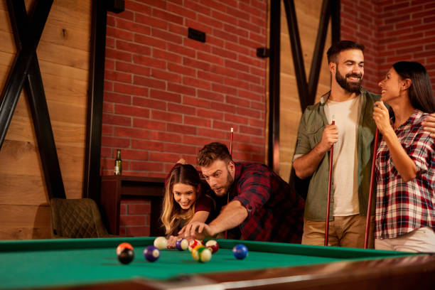 istock Group of friends having fun while playing pool in a local pool hall 1372564869