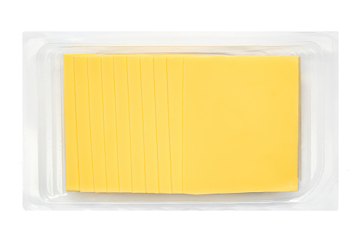 Slices of cheese for sandwiches  isolated on white background in a package, top view. Cutted cheese closeup