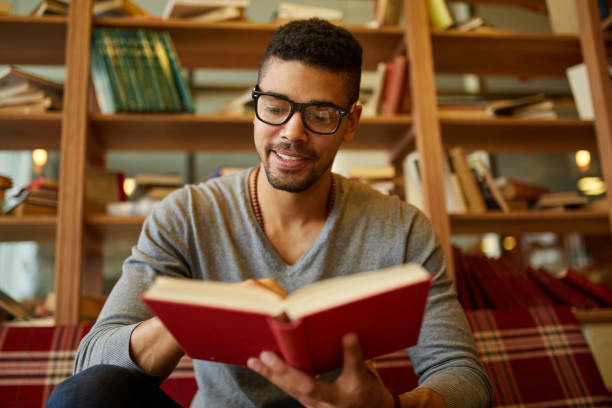 istock Smiling African American student enjoying book reading in library 1372567241
