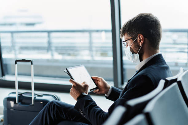 istock businessman in a protective mask using a digital tablet at the a 1372568281