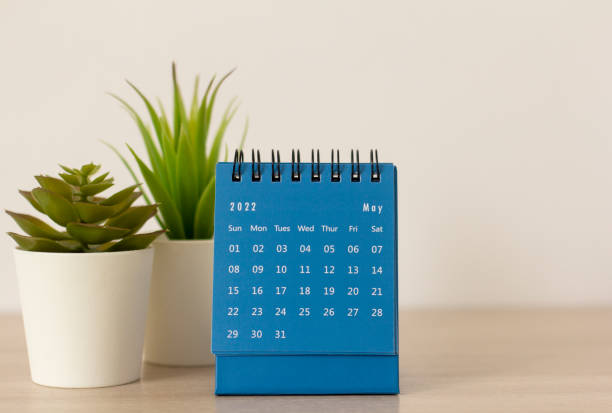 istock Desktop blue calendar for May 2022 on the table. 1372569219