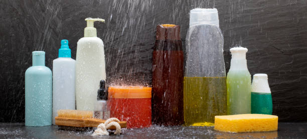Personal hygiene products in the shower splashed by shower water on black ceramic stock photo