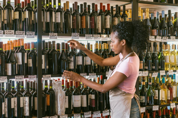 właściciel sklepu z winami sortujący butelki wina - wine bottle liquor store wine variation zdjęcia i obrazy z banku zdjęć