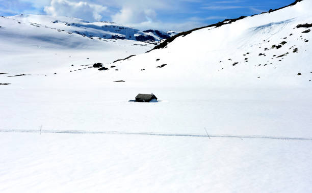 istock Winter panorama with a snow-covered cabin in a lonely snowbound mountain range 1372576083