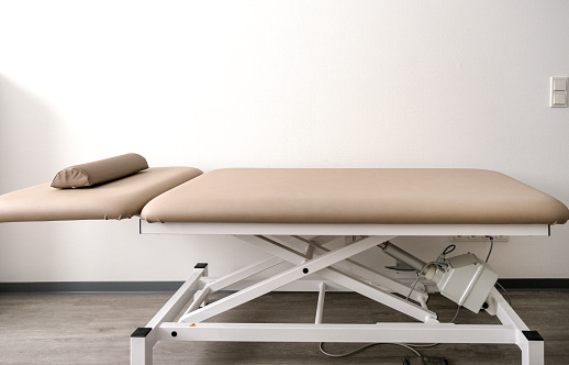 Front view: Empty adjustable examination couch or treatment couch in a doctor's office, clinic or physiotherapy practice