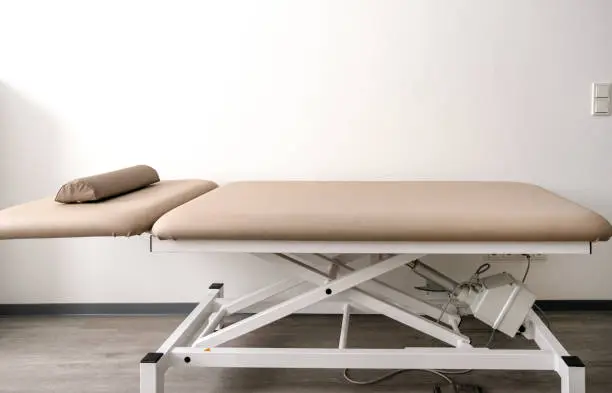 Photo of Empty adjustable examination couch or treatment couch in a doctor's office, clinic or physiotherapy practice