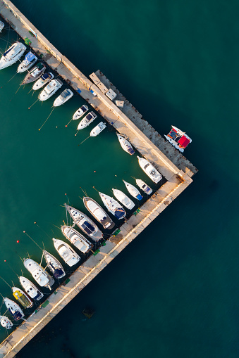 Top aerial view of a straight corner of a marina with boats