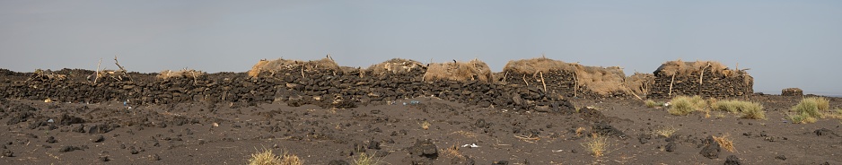 Landscape panorama view of traditional houses in front of Erta Ale Volcano in the remote regions of Ethiopia.