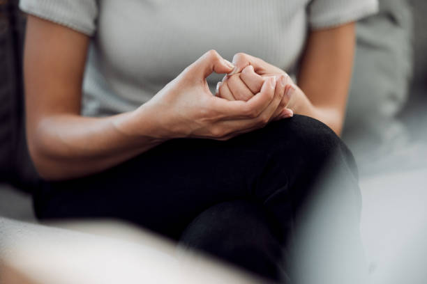 Cropped shot of an unrecognisable woman sitting alone and feeling anxious while picking the skin on her nails A common sign of anxiety is subconscious skin picking victim advocacy stock pictures, royalty-free photos & images