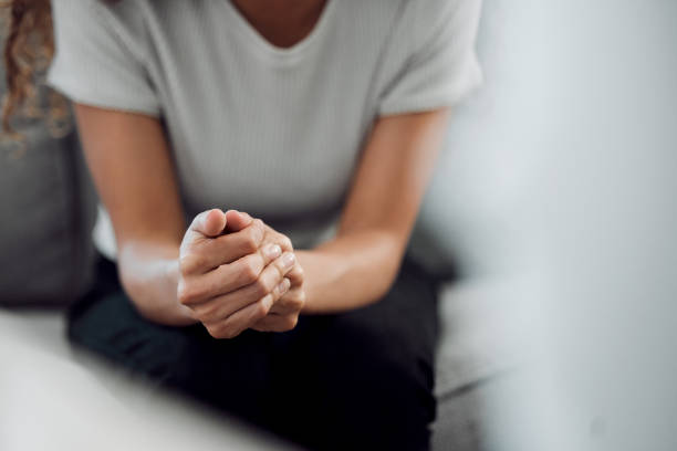 photo recadrée d’une femme méconnaissable assise seule et se sentant anxieuse pendant sa consultation - comportement addictif photos et images de collection