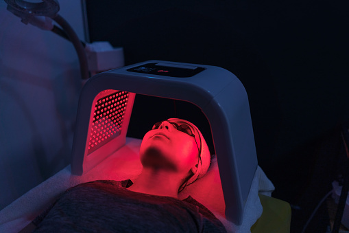 Paciente joven que recibe tratamiento con luz LED photo