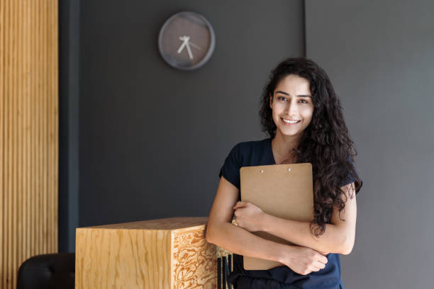 istock Female physical therapist holding clipboard and smiling 1372579266