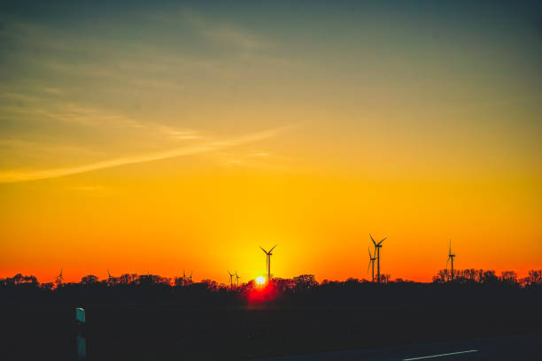 Wind turbines in the landscape with setting sun.