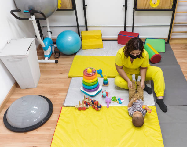 istock Physical therapist holding baby's legs on mat 1372581299