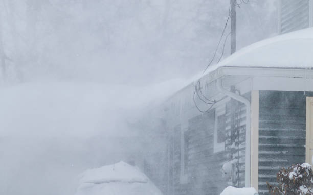 istock Snow blowing off a roof during a blizzard creating white out conditions 1372582233