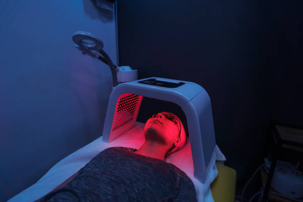 Young woman doing red light therapy on face A young latin woman doing a red light therapy on her face. light therapy stock pictures, royalty-free photos & images