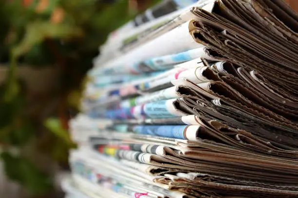 Photo of A stack of old newspapers lie on a table