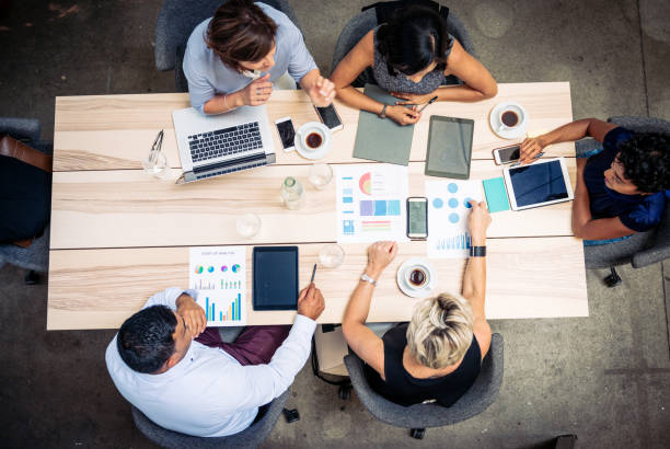 istock Overhead view of diverse business people working in office 1372584253