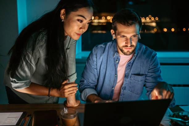 istock Colleagues working late at night in the office. 1372588204
