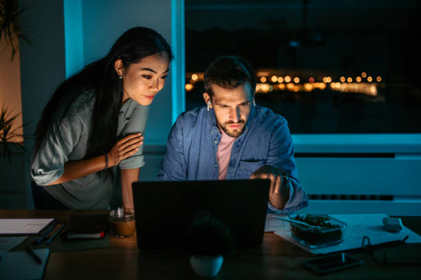 istock Colleagues working late at night in the office. 1372588310