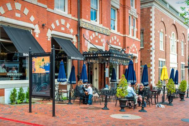 People sit on a restaurant patio in downtown Salem, Massachusetts, USA on a cloudy day.