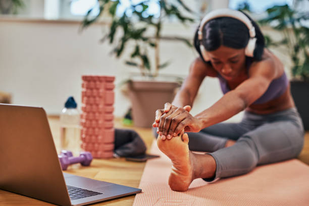 istock Female exercising at home, online workout on laptop 1372590673
