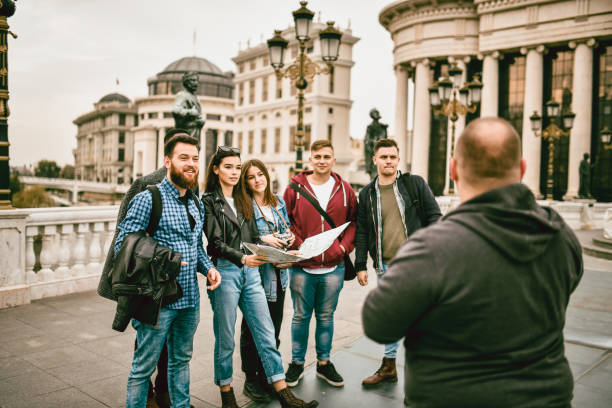 istock Rear View Of Tour Guide Explaining Local History To Group 1372590678