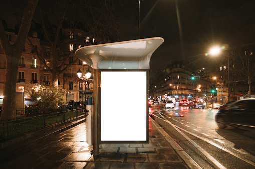 A bus stop with a blank poster / billboard for advertisements at night
