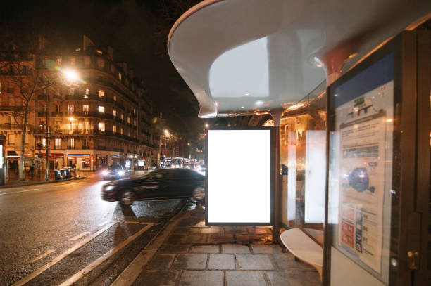 A bus stop with a blank poster / billboard for advertisements at night