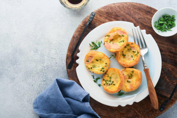 istock Egg muffins with green onions, bacon, cheese and tomatoes on white plate on light background. Healthy high protein and low carb breakfast, ready to eat. 1372592262