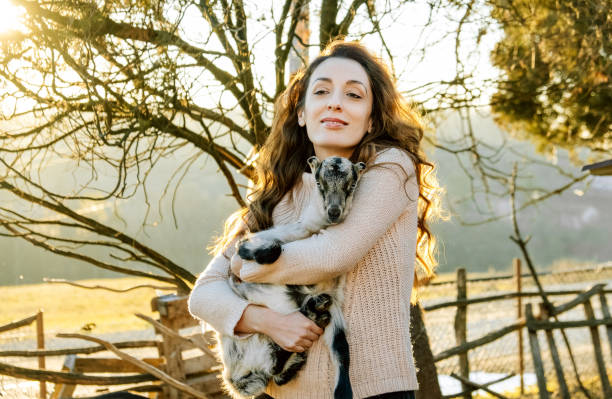 istock Woman Holding Baby Goat 1372601746