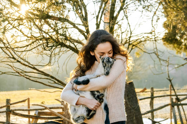 istock Woman Holding Baby Goat 1372601763