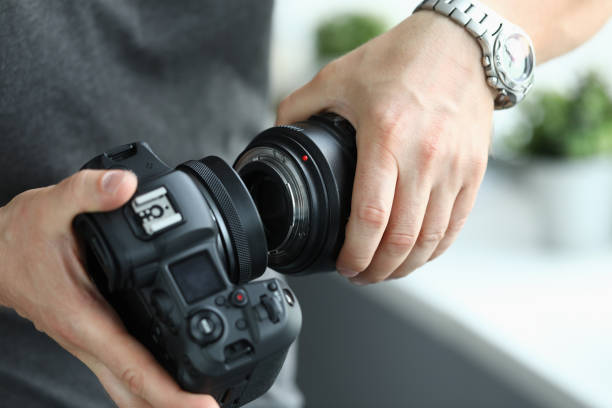 istock Male hands putting on modern digital camera professional lens 1372603642