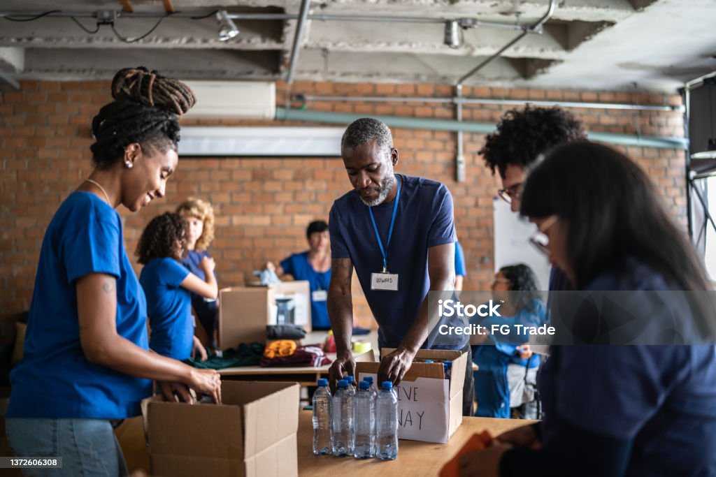 Volunteers arranging donations in a community charity donation center Volunteer Stock Photo