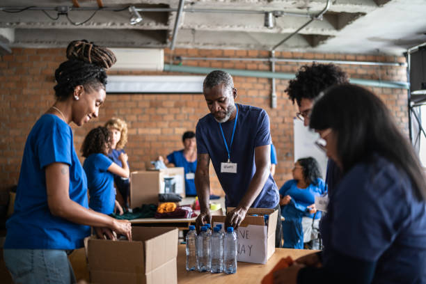 Volunteers arranging donations in a community charity donation center Volunteers arranging donations in a community charity donation center humanitarian aid stock pictures, royalty-free photos & images