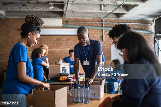 Volunteers Arranging Donations In A Community Charity Donation Center Stock Photo - Download Image Now