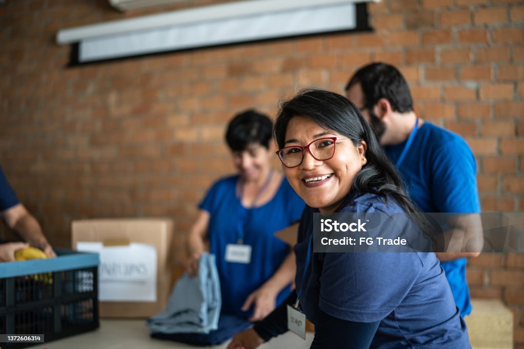 Portrait of a volunteer working in a community charity donation center Volunteer Stock Photo