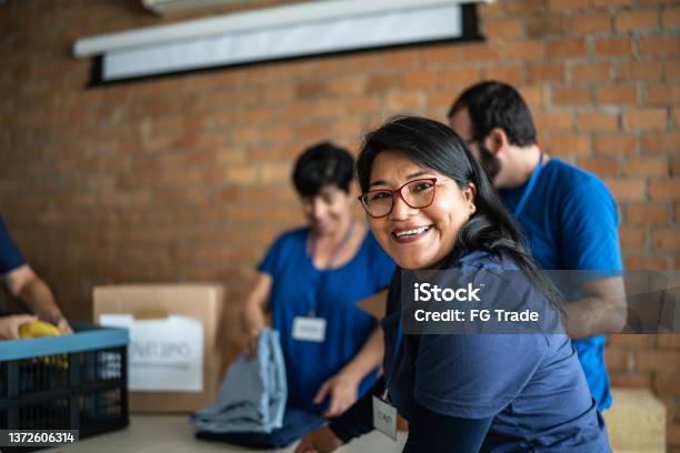 Portrait Of A Volunteer Working In A Community Charity Donation Center Stock Photo - Download Image Now